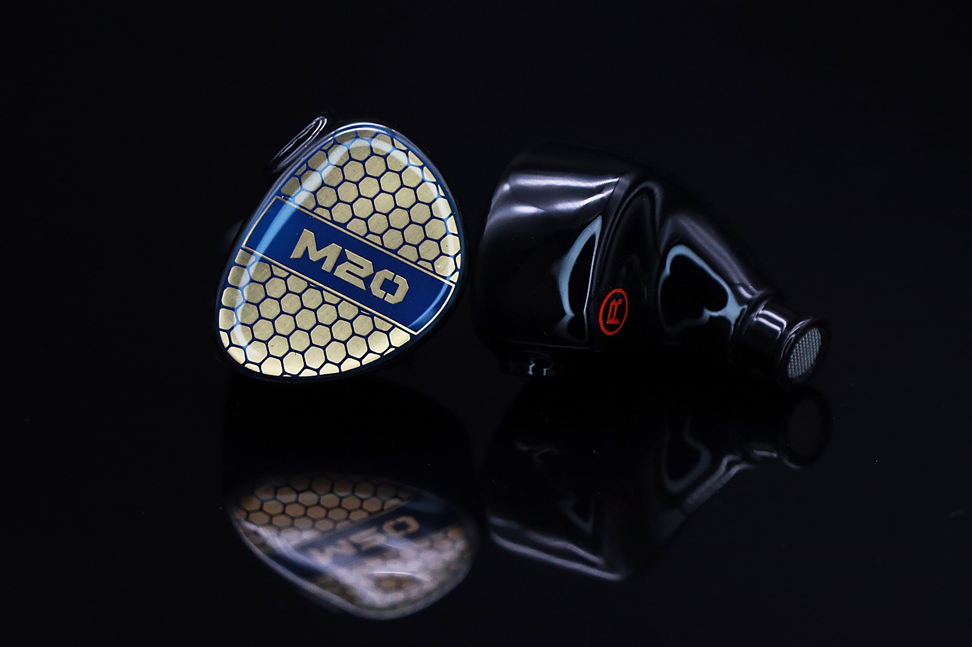AAW M20 monitors with detachable cable and 3.5mm plug on black reflective surface